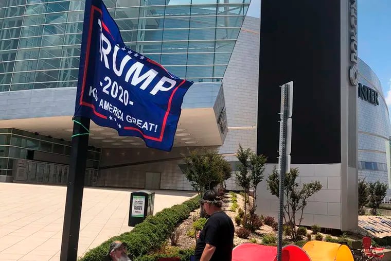 James Massery, left, of Preston, Okla., and Daniel Hedman, of Tulsa, Okla., supporters of President Donald Trump, camp outside the BOK Center in Tulsa four days before his scheduled rally Saturday. President Donald Trump's campaign says six staff members helping set up for his Saturday night rally in Tulsa, Oklahoma, have tested positive for coronavirus.