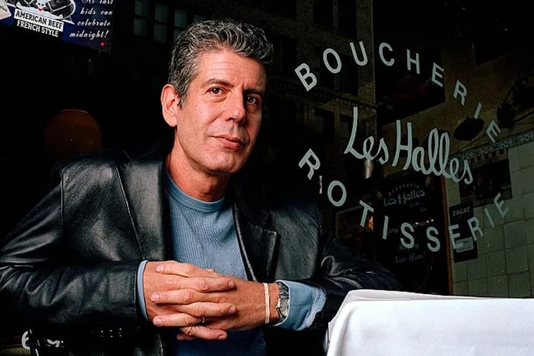 Anthony Bourdain, the owner and chef of Les Halles restaurant, sitting at one of its tables in New York in 2001. 