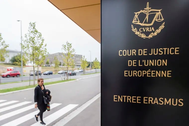 In this photo taken on Monday, Oct. 5, 2015 a woman walks by the entrance to the European Court of Justice in Luxembourg. The European Union's top court ruled Monday, Dec. 10, 2018, that Britain can change its mind over Brexit, boosting the hopes of people who want to stay in the EU that the process can be reversed. (AP Photo/Geert Vanden Wijngaert)