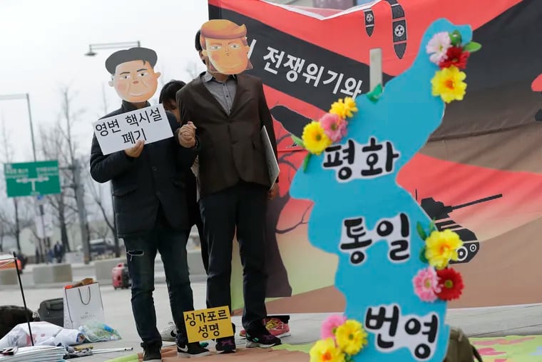 Protesters wearing masks of U.S. President Donald Trump and North Korean leader Kim Jong Un stand near the map of Korean Peninsula during a rally demanding the denuclearization of the Korean Peninsula and peace treaty near the U.S. embassy in Seoul, South Korea, Thursday, March 21, 2019. The Korean Peninsula remains in a technical state of war because the 1950-53 Korean War ended with an armistice, not a peace treaty. More than 20 protesters participated at a rally and also demanding the end the Korean War and to stop the sanction on North Korea. The letters read "Peace and Unification."