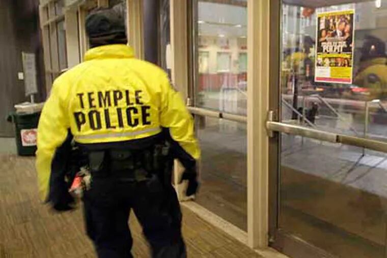 A Temple University police officer patrols outside the Liacouras Center yesterday. The school plans to hire at least 10 police officers and additional security staff.