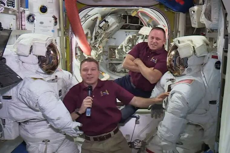 Before their walk, astronauts Terry Virts (left) and Butch Wilmore hung out near their spacesuits aboard the International Space Station during an interview Wednesday. They have two more walks to go.
