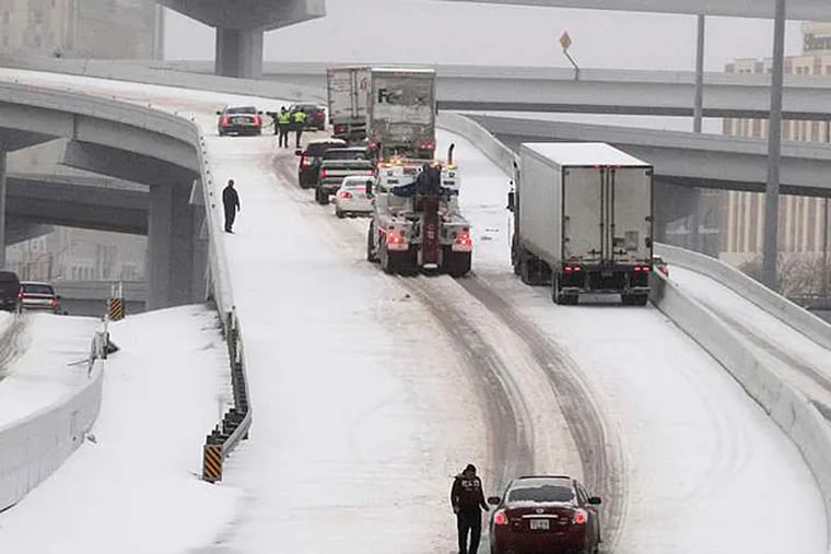 Motorists attempt to negotiate a treacherously icy highway ramp in Fort Worth. Earlier in the week, temperatures in Texas soared into the 80s. RON T. ENNIS / Fort Worth Star-Telegram / MCT