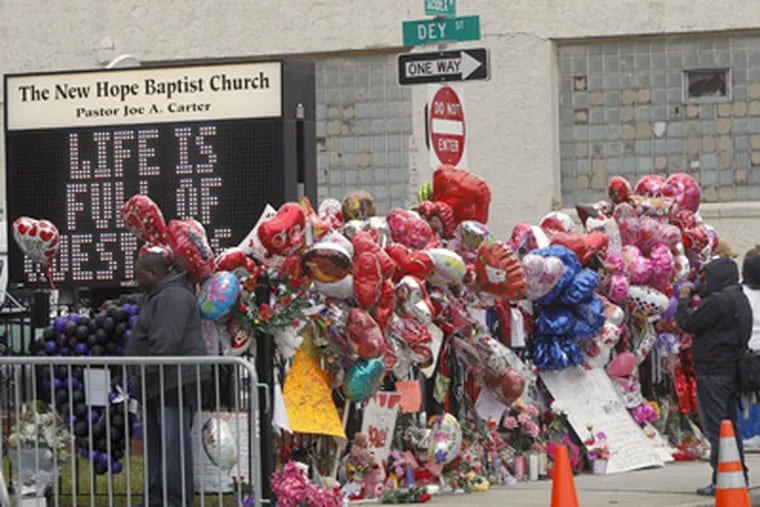 Fans created a makeshift memorial at the New Hope Baptist Church in Newark for Whitney Houston, a native of that city who died Saturday at 48. (Rich Schultz / Associated Press)