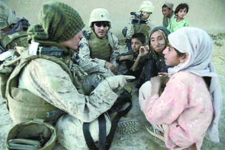 Marine First Lt. Victoria Sherwood of Woodbury, Conn., talks with 8-year-old Bibi Asha and her grandmother Nazu in the village of Khwaja Jamal. Finding the Afghan women is often difficult.