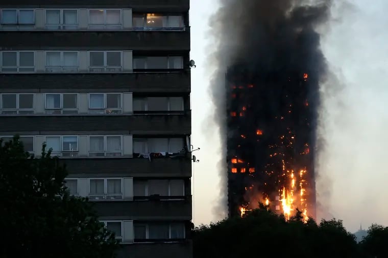 FILE  - In this Wednesday, June 14, 2017 file photo, smoke and flames rise from the Grenfell Tower, in London. Police investigating a blaze that killed 72 people in a London tower block two years ago say no one is likely to face criminal charges until 2021. (AP Photo/Matt Dunham, File)