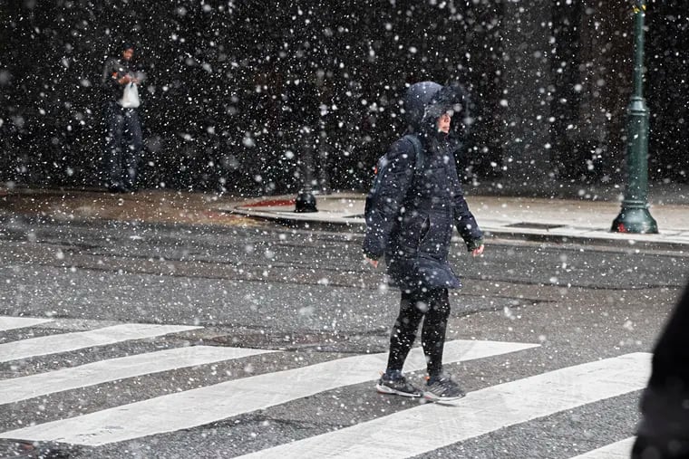 Remember this stuff? Here a pedestrian crosses a Center City street during a rare wintry moment last month. We haven't seen much snow this winter, and that has been the case in winters past.