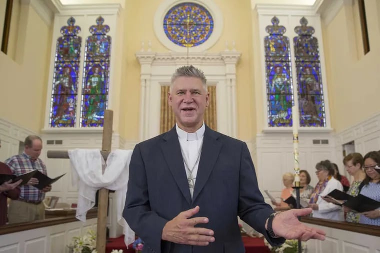 Rev. Timothy Thomson-Hohl, pastor of Ardmore United Methodist Church, rejoices in the Easter Sunday unveiling of four stained glass windows of gospel-writing saints Matthew, Mark, Luke and John that came from Bala Cynwyd UMC after it closed and merged with his congregation.