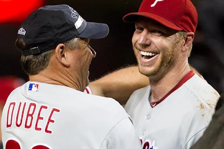 Philadelphia Phillies pitcher Roy Halladay, right, gets a hug from pitching coach Rich Dubee after the Phillies defeated the Washington Nationals 8-0 to clinch the National League East on Monday, Sept. 27, 2010, in Washington. (AP Photo/Evan Vucci)
