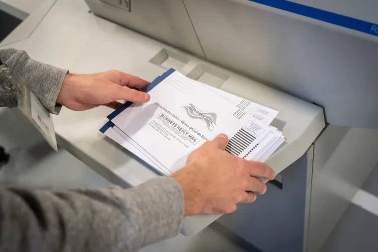 An elections worker organizes Philadelphia mail ballots.