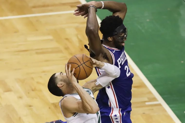 Sixers center Joel Embiid fouls Boston Celtics forward Jayson Tatum during the fourth-quarter in game two of the Eastern Conference semifinals on Thursday, May 3, 2018 in Boston.