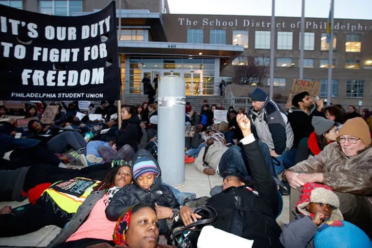 Students and supporters participate in a "die-in" at school district headquarters along North Broad Street on Thursday, Dec. 18, 2014. ( YONG KIM / Staff Photographer )