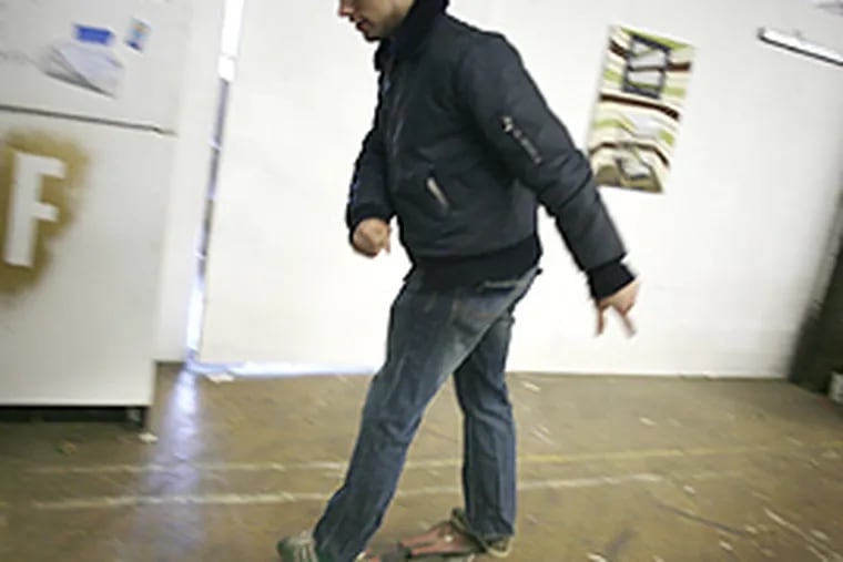 Chris Golas rides around the Art Making Machine Studio, a big warehouse that has been turned into artist studios on N. Hope Street. (Eric Mencher/Inquirer)