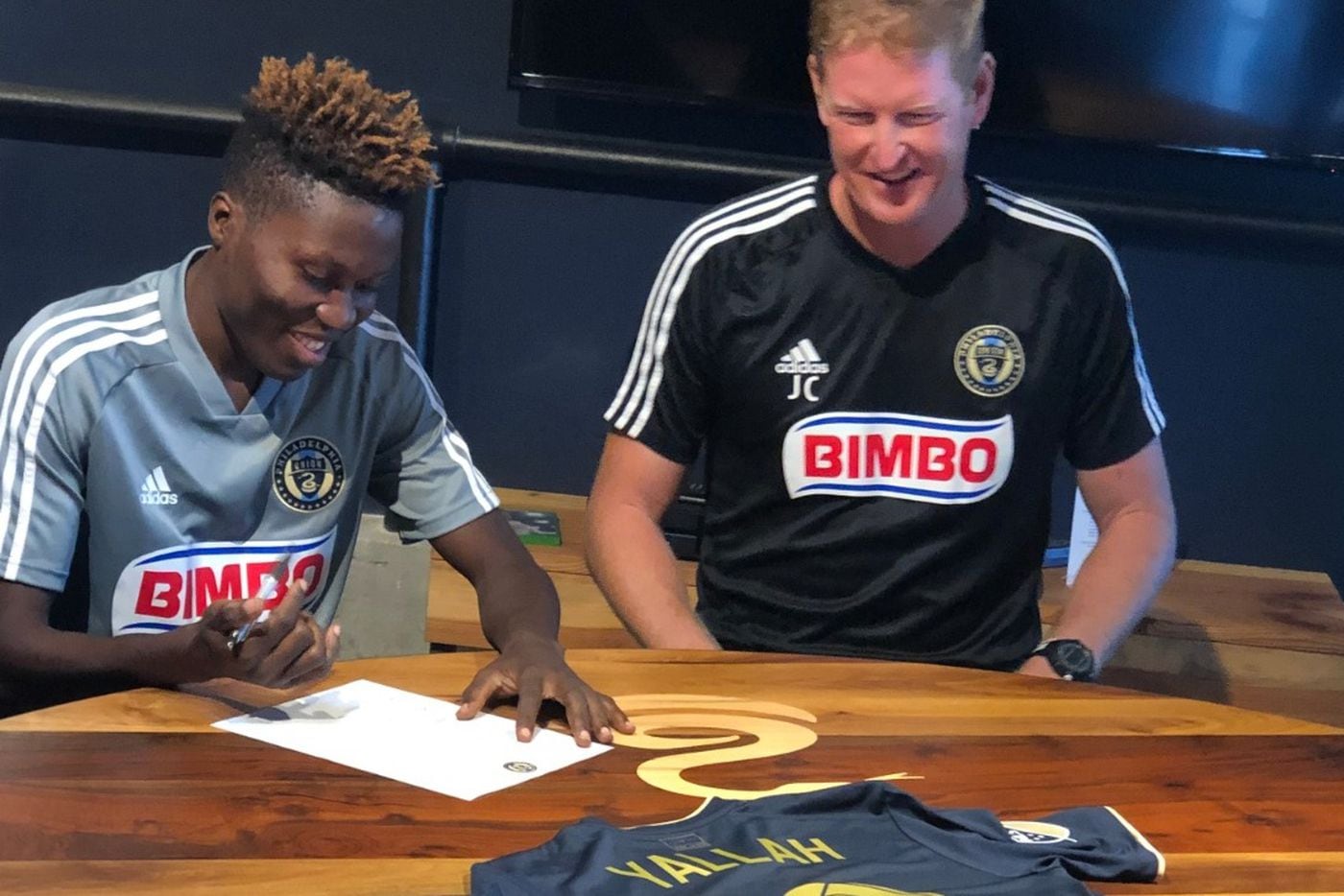 Daniel Yallah signs a one-day contract with the Philadelphia Union to play with the team on Sept. 21. Head coach Jim Curtin looks on.