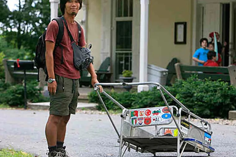 'Planet' walker Masahito Yoshida in Fairmount Park with his cart. He is staying at the hostel at Chamounix Mansion while his cart is being repaired. (Akira Suwa/Staff)
