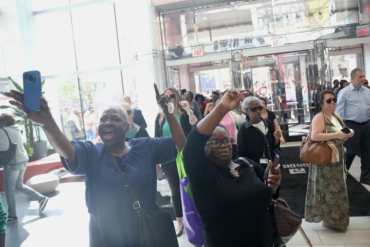Shoppers celebrate as they are among the first to enter the Fashion District mall in Center City on Thursday. The Fashion District is the long-awaited replacement for the former Gallery mall, which occupied the same space.