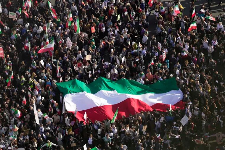 People hold Iranian flag during a protest against the Iranian regime, in Berlin, Germany, Saturday, Oct. 22, 2022, following the death of Mahsa Amini in the custody of the Islamic republic's notorious "morality police."