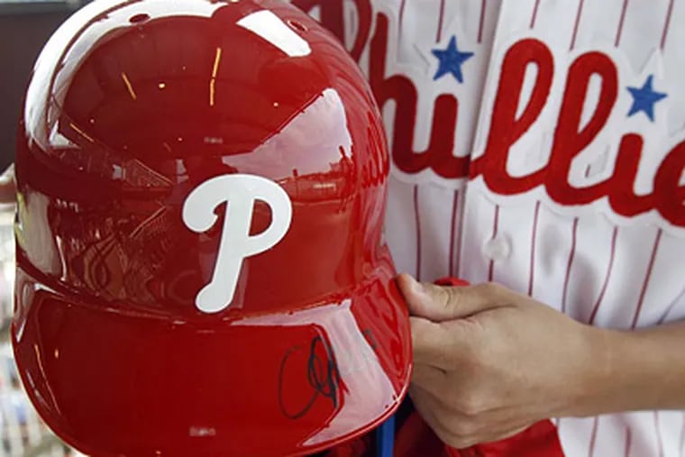 John Gentile holds a Cliff Lee autographed batting helmet during the Phillies ALS Phestival on Monday.  (Yong Kim / Staff Photographer)