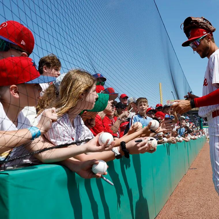 Phillies shortstop Trea Turner signs his autograph for fans before a spring training game against the Rays.