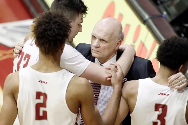 St. Joesph's head coach Phil Martelli hugs his starters as they come back to the bench late in the fourth quarter of Friday night's win over St. Louis