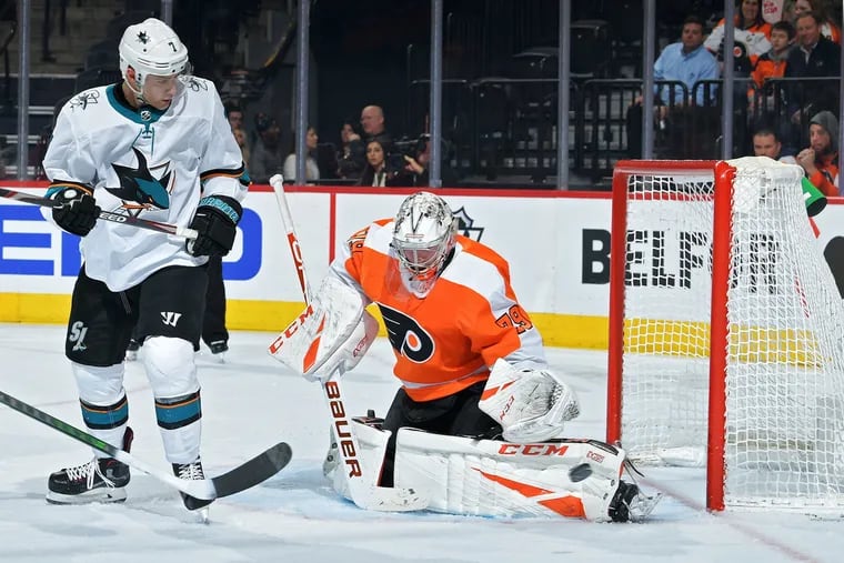 Flyers goaltender Carter Hart, shown making a save as the San Jose Sharks' Dylan Gambrell  looks on in a Feb. 25 game, will play the first two periods in Tuesday's exhibition game against Pittsburgh in Toronto.