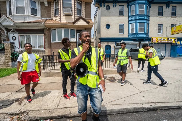 Jon McKay, center, executive director of Life Outside the Streets, walked with student volunteers of the anti-violence nonprofit Philly Truce while they were out on their Peace Patrol program in the Cobbs Creek community on July 7.