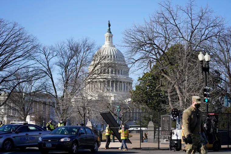 Workers install no-scale fencing around the U.S. Capitol on Thursday.