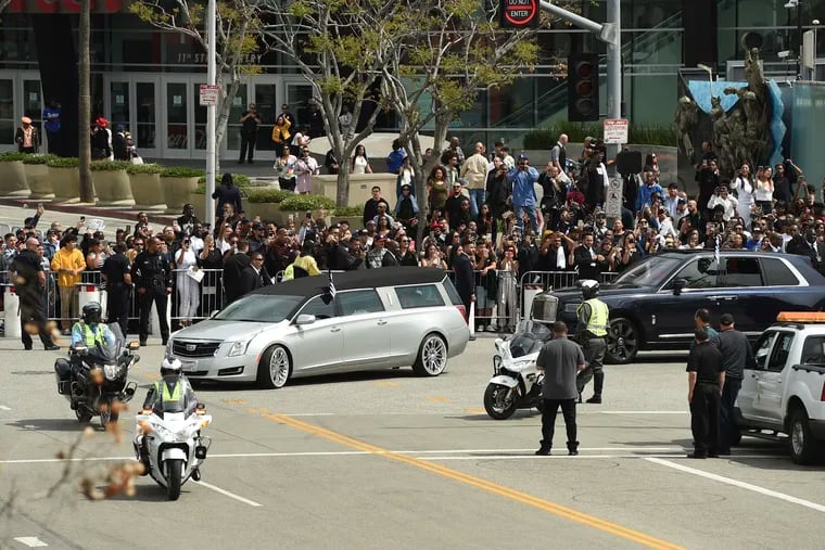 A silver hearse carrying the body of Nipsey Hussle, whose given name was Ermias Asghedom, leaves Staples Center in a procession following the Celebration of Life memorial service for the late rapper on Thursday, April 11, 2019, at the Staples Center in Los Angeles. (Photo by Chris Pizzello / Invision / AP)