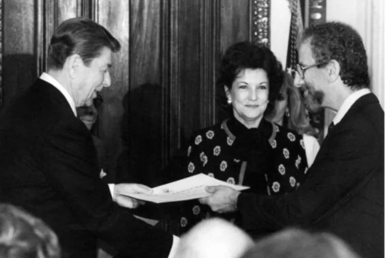 Mr. Cook (right) accepts an award from President Ronald Reagan on Jan. 30, 1985, as Elizabeth Dole, the Secretary of Transportation, looks on.