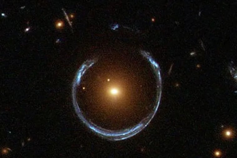 KH-Gravitational-Lensing: This NASA Hubble image shows a phenomenon known as gravitational lensing. Gravity bends light, sometimes distorting and magnifying images of distant objects. Scientists say the repurposed spy satellites would be well suited to using gravitational lensing to explore the nature and distribution of dark matter and search for planets around other stars.