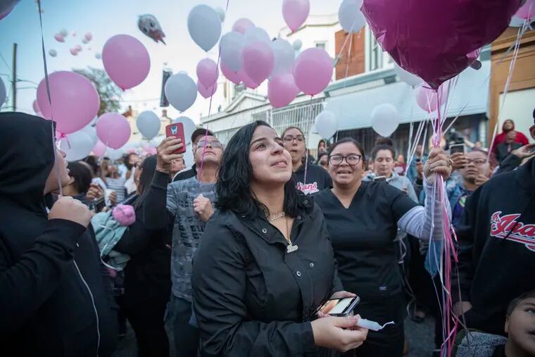 Joan Pagan, center, the mother of Nikolette Rivera, the 2-year-old who was shot and killed on Sunday, watches the release of pink and white balloons as a tribute to her daughter.