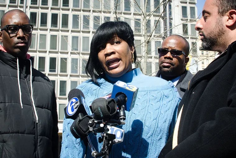 Tanya Dickerson, mother of Brandon Tate-Brown speaks to reporters in March after receiving news that the officers involved in the shooting will not be charged in his death. With her are Asa Khalif, Tate-Brown's cousin (left); and Brian Mildenberg, attorney (far right).