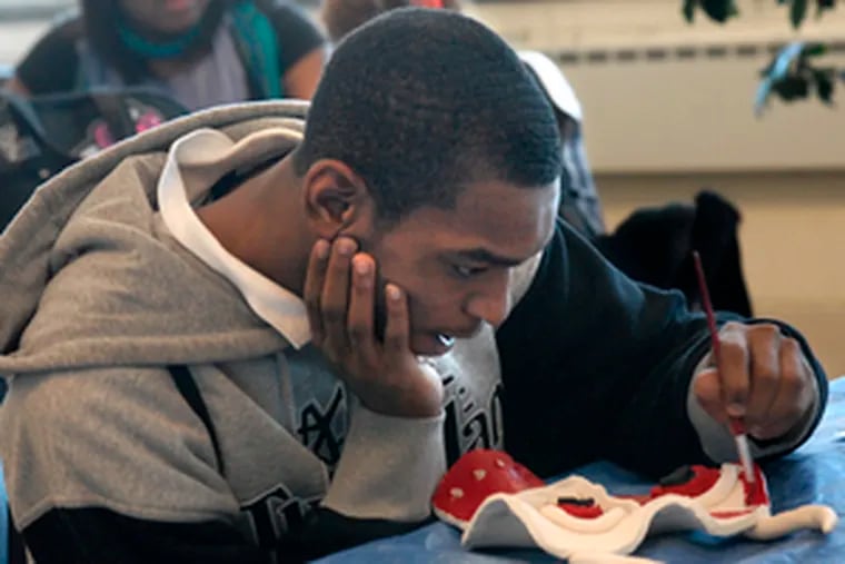 Terrence Lambert works on a mask he created with Claymobile at Strawberry Mansion High School.