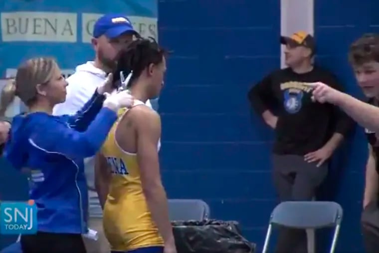 Andrew Johnson gets his hair cut minutes before his wrestling match on the order of a referee, who told Johnson he could either cut his dreadlocks or forfeit.