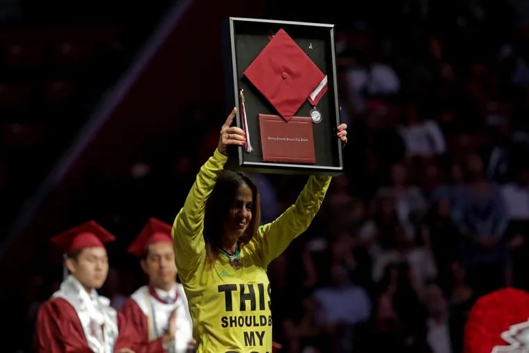 Joaquin Oliver's mother, Patricia, holds up her son's high school diploma, which was awarded posthumously, during a graduation ceremony. Oliver was one of 17 people killed during a massacre at Marjory Stoneman Douglas High School.
