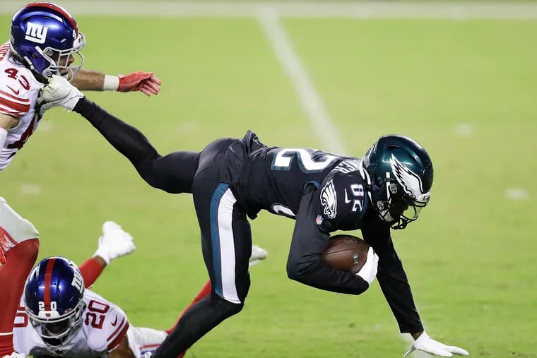 Eagles wide receiver John Hightower lunges forward after catching a fourth-quarter pass past Giants defensive back Nate Ebner and free safety Julian Love on Thursday.
