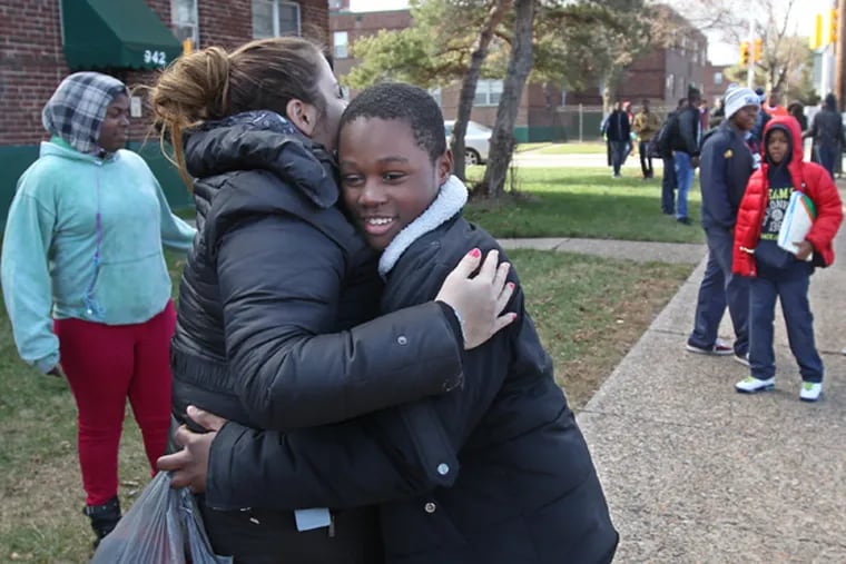 Kyseem Moore, 12, right, gives his school counselor, Emily Goodman, left, a big hug after the final day of classes at Wakisha Charter School on Friday afternoon at 1 p.m., Dec. 19, 2014. (Michael Bryant/Staff Photographer)