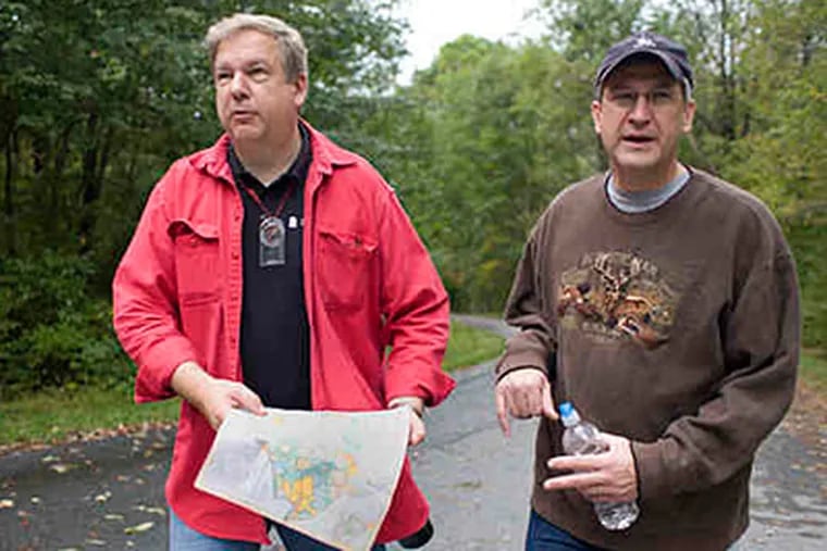 Tom Varga (left) of West Bradford and Mark Jurchak of Chadds Ford seek clues in French Creek State Park during the retreat. (Ed Hille/Staff)