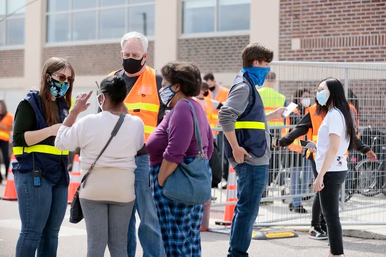 FEMA employees (wearing striped vests) help people who speak languages other than English get the COVID-19 vaccine at FEMA’s mass vaccination site at the Esperanza Community Center in the Hunting Park section of Philadelphia on April 10, 2021.