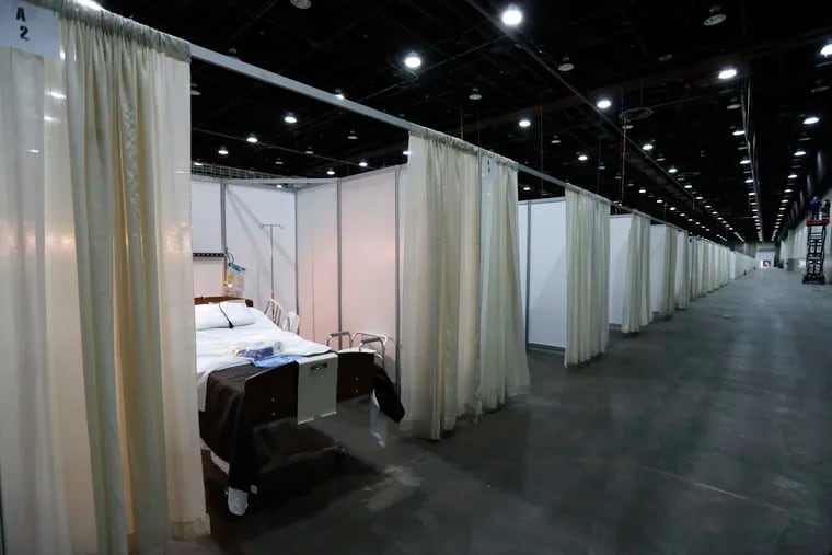 This photo shows a hospital bed in one of the temporary rooms at the TCF Center, Monday, April 6, 2020, in Detroit. The city's convention center was converted to accommodate an overflow of patients with the coronavirus. (AP Photo/Carlos Osorio)