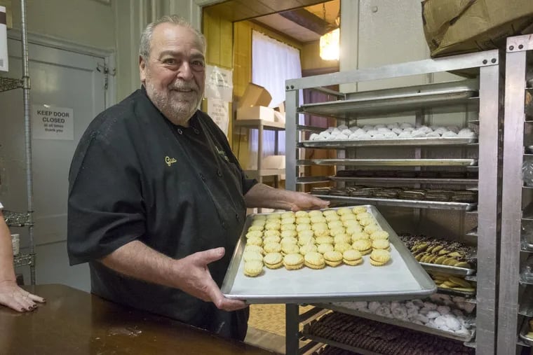 Gus Isgro stands with a fresh batch of raspberry-filled butter cookies near his grandmother's table. He can't bear to part with the table despite the pleas of his bakery staff during the holiday rushes of Easter and Christmas.