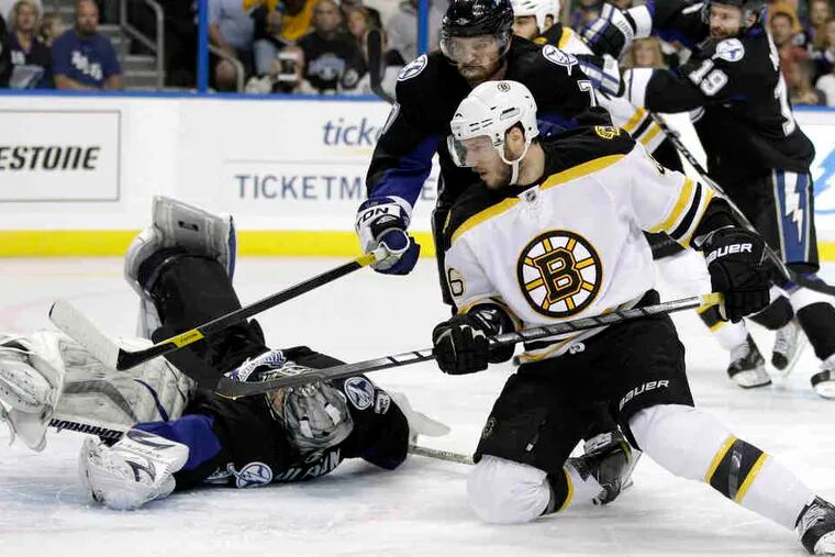 Boston's David Krejci scores against Tampa Bay goalie Dwayne Roloson in the first period of Game 3 in the Eastern Conference finals. Thursday night's game ended too late for this edition.