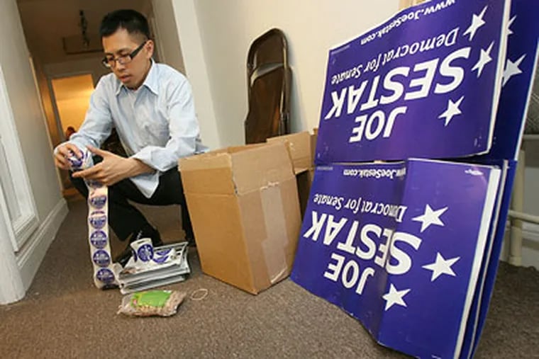 Campaign volunteer Clarence Tong works past midnight Wednesday assembling packets of stickers and fliers that will be distributed at commuter train stations in the morning. (Charles Fox / Staff Photographer)