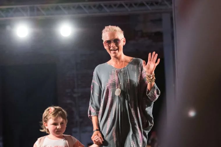 Sherry Pollex, who with boyfriend Martin Truex Jr. founded the fund-raiser Catwalk for a Cause, walks down the catwalk with a child with cancer.