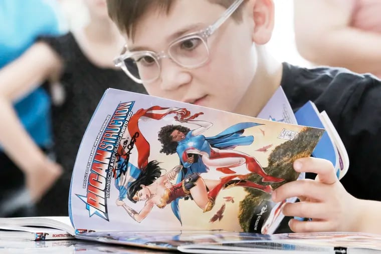 Lucca Petrecca, 11, of Princeton reads the comic book "Ricanstruction," which author Edgardo Miranda-Rodriguez just signed at Taller Puertorriqueno in Phila., Pa. on June 16, 2018.