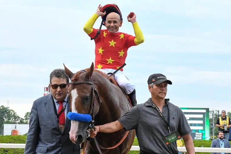 Jockey Mike Smith celebrates after Justify wins the Triple Crown at the 150th Belmont Stakes, in Elmont, N.Y., on Saturday.