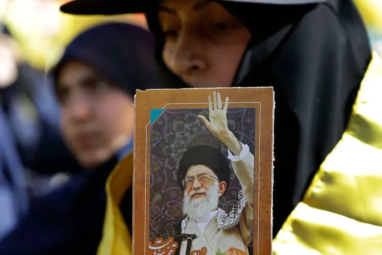 Listening to Nasrallah's speech , which was broadcast at the Mashghara rally, a woman holds a picture of Iran's Ayatollah Ali Khamanei. HUSSEIN MALLA / Associated Press