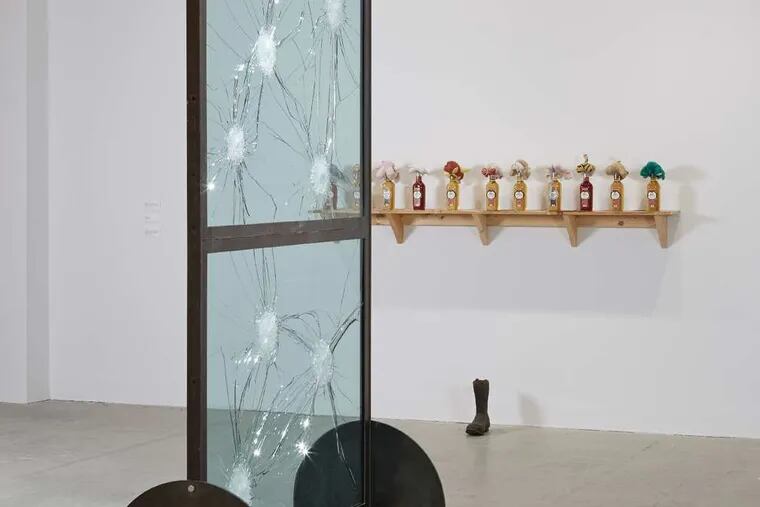 Stripped Bare&quot; by Kendell Gere, glass and steel, and in the background, &quot;Alcohol Shelf&quot; by William Pope.L, featuring bottles, reconstituted wine, and stuffed animals, in the &quot;Ruffneck Constructivists&quot; show at the Institute of Contemporary Art.