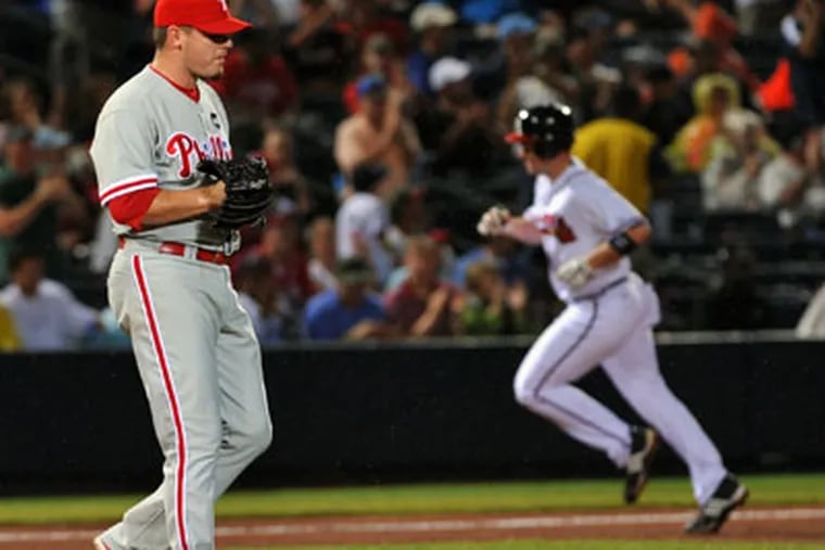 Philadelphia Phillies' Chad Durbin, left, walks away from the mound as Atlanta Braves' Matt Diaz, right, rounds the bases after hitting a home run during the fifth inning of a baseball game on Saturday, Sept. 19, 2009, at Turner Field in Atlanta. (AP Photo/Gregory Smith)