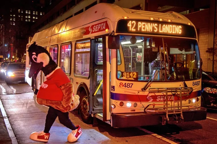 RESENDING FOR BETTER COLOR RENDERING: Wawa mascot Wally Goose jumps off a #42 bus to attend a preview night December 12, 2018,  before opening its largest store ever at 6th and Chestnut. The event  included the unveiling of a new Mural Arts Philadelphia program mural called "Philly Firsts" inside the store.  Wally didn'tarrie by bus, but had just gone onboard briefly to greet the driver. TOM GRALISH / Staff Photographer